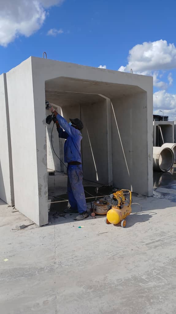 A worker finishing the interior surface of a precast concrete culvert