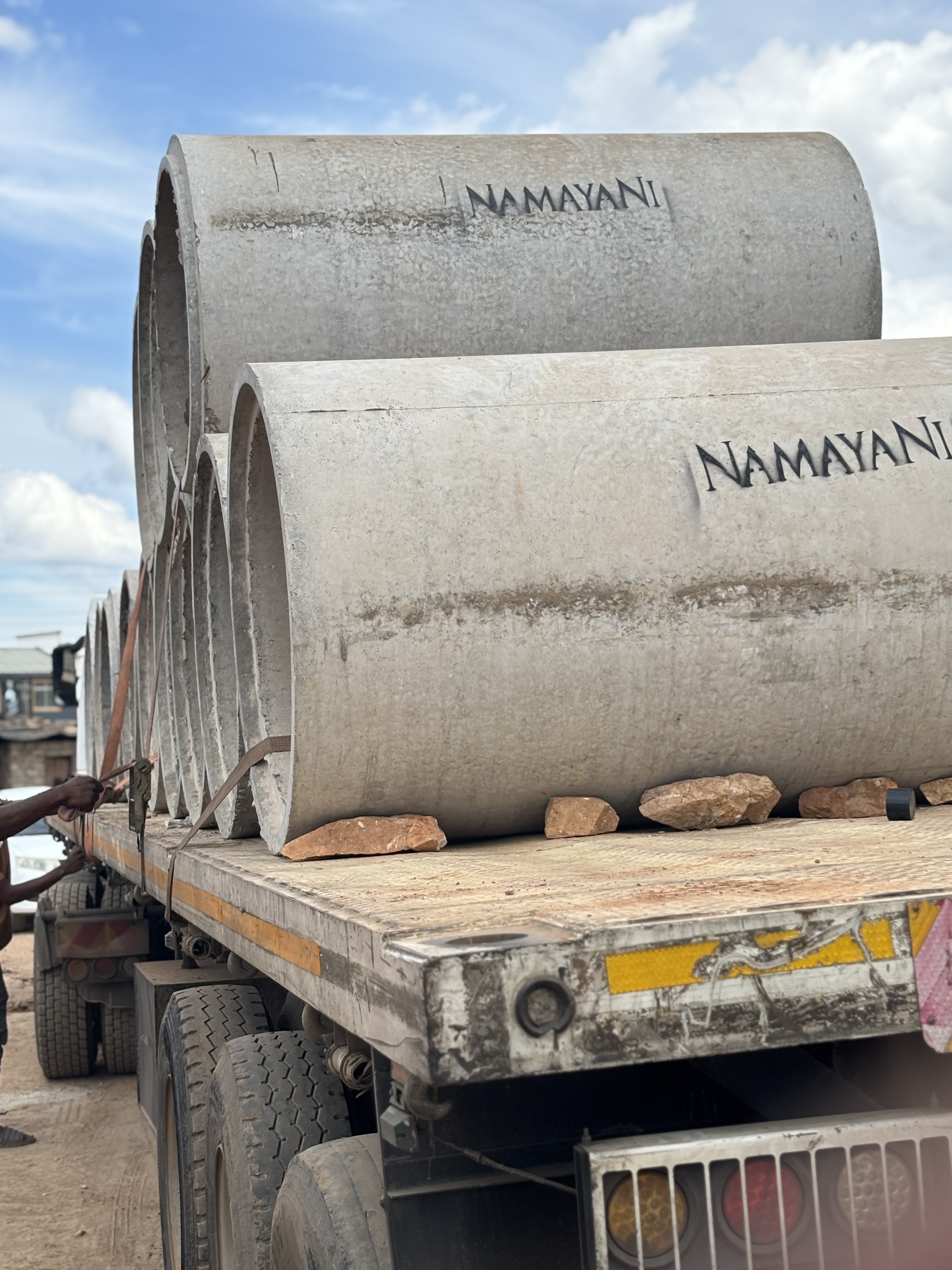 Namayani-stencilled concrete drainage pipes loaded on a flatbed truck