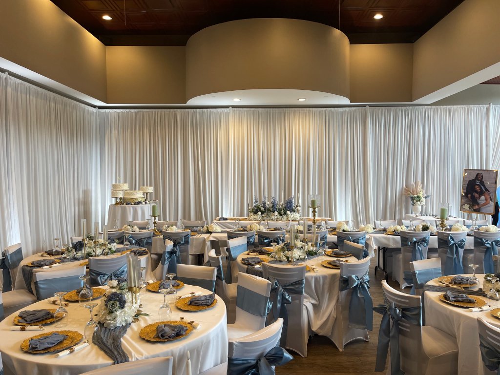 Wedding reception with dusty-blue sashes and gold chargers