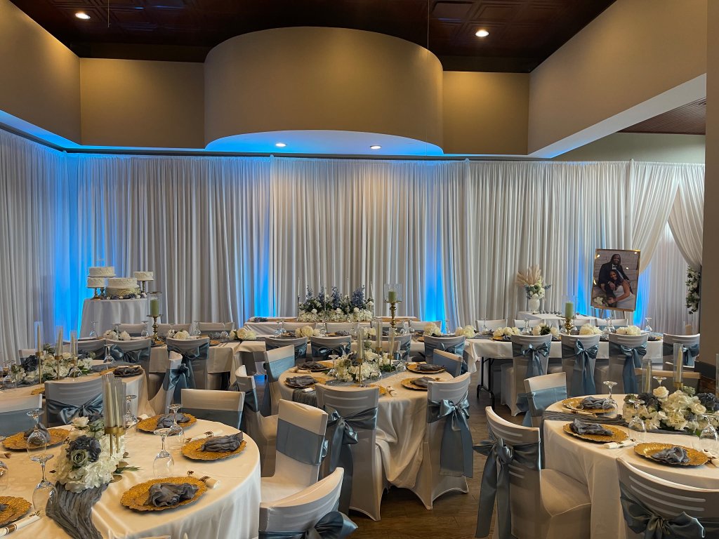 Reception hall with white drapes and blue uplighting