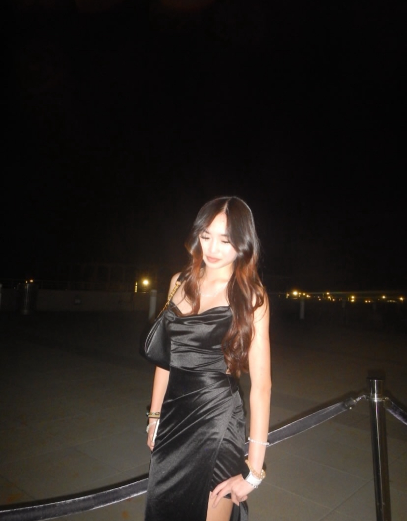 Portrait of Jae-i Hong in a black satin dress outdoors at night