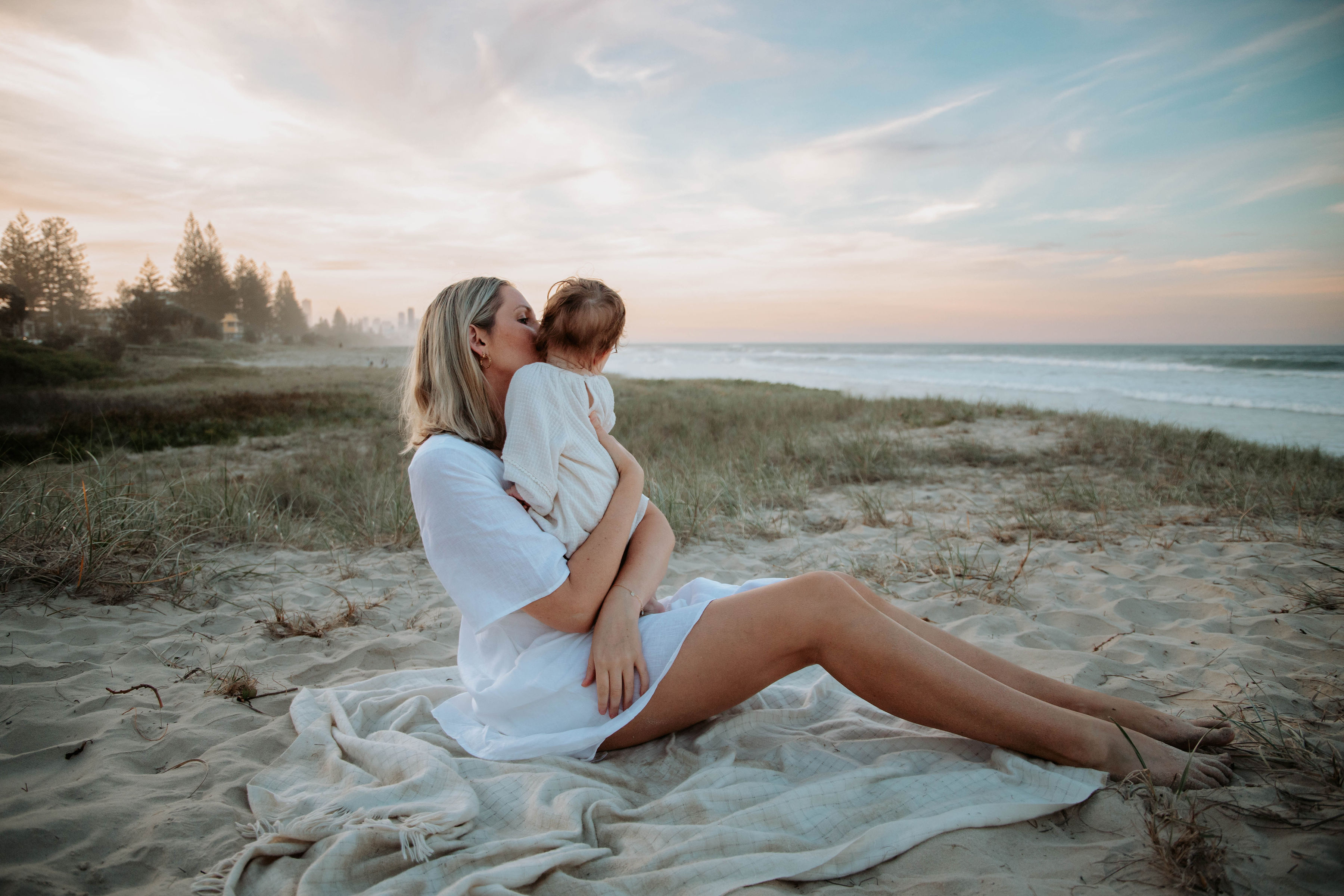 Melissa and her daughter on the beach at sunset
