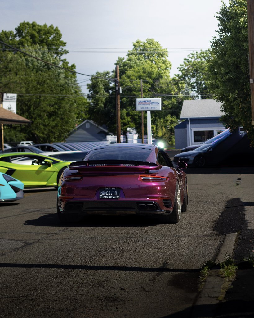 Metallic purple Porsche 911 rear view at Ulmer's Auto Care with Lamborghini and Audi R8
