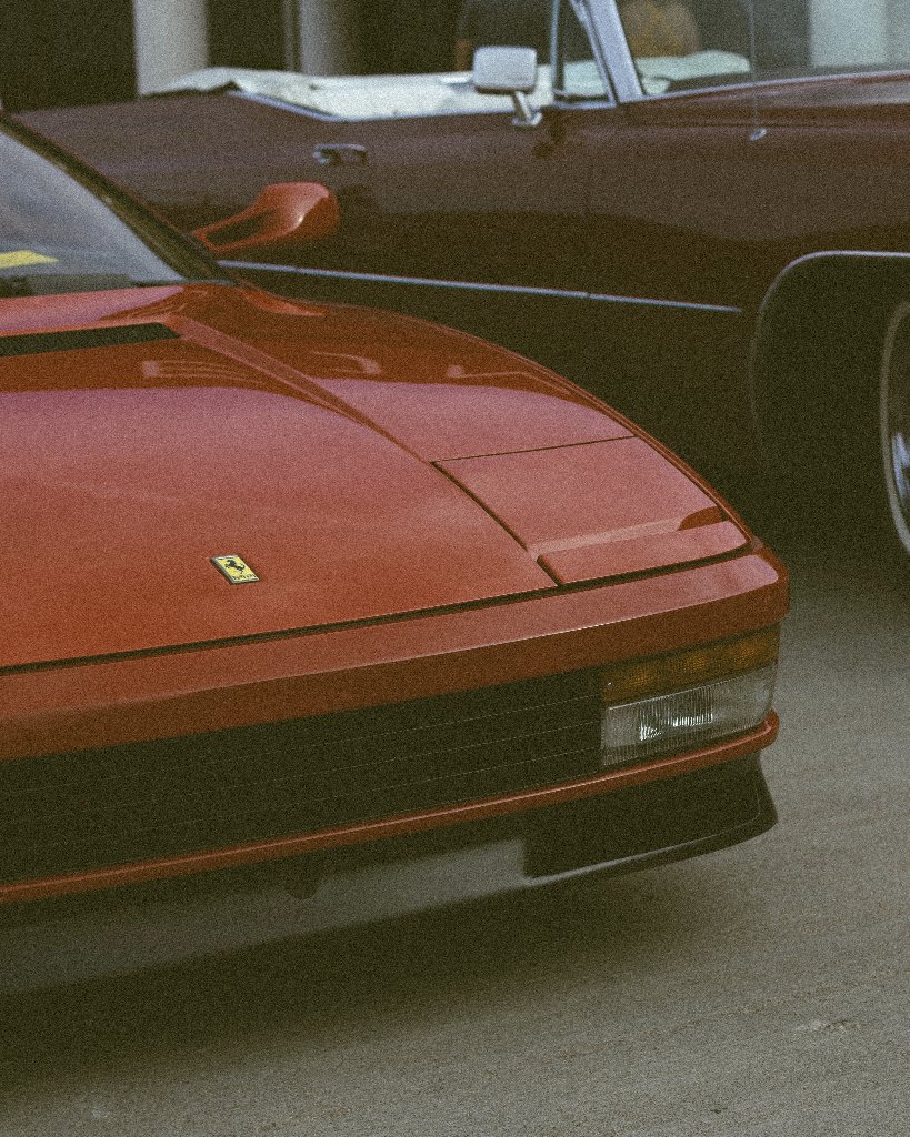 Close-up of vintage red Ferrari front end with yellow badge
