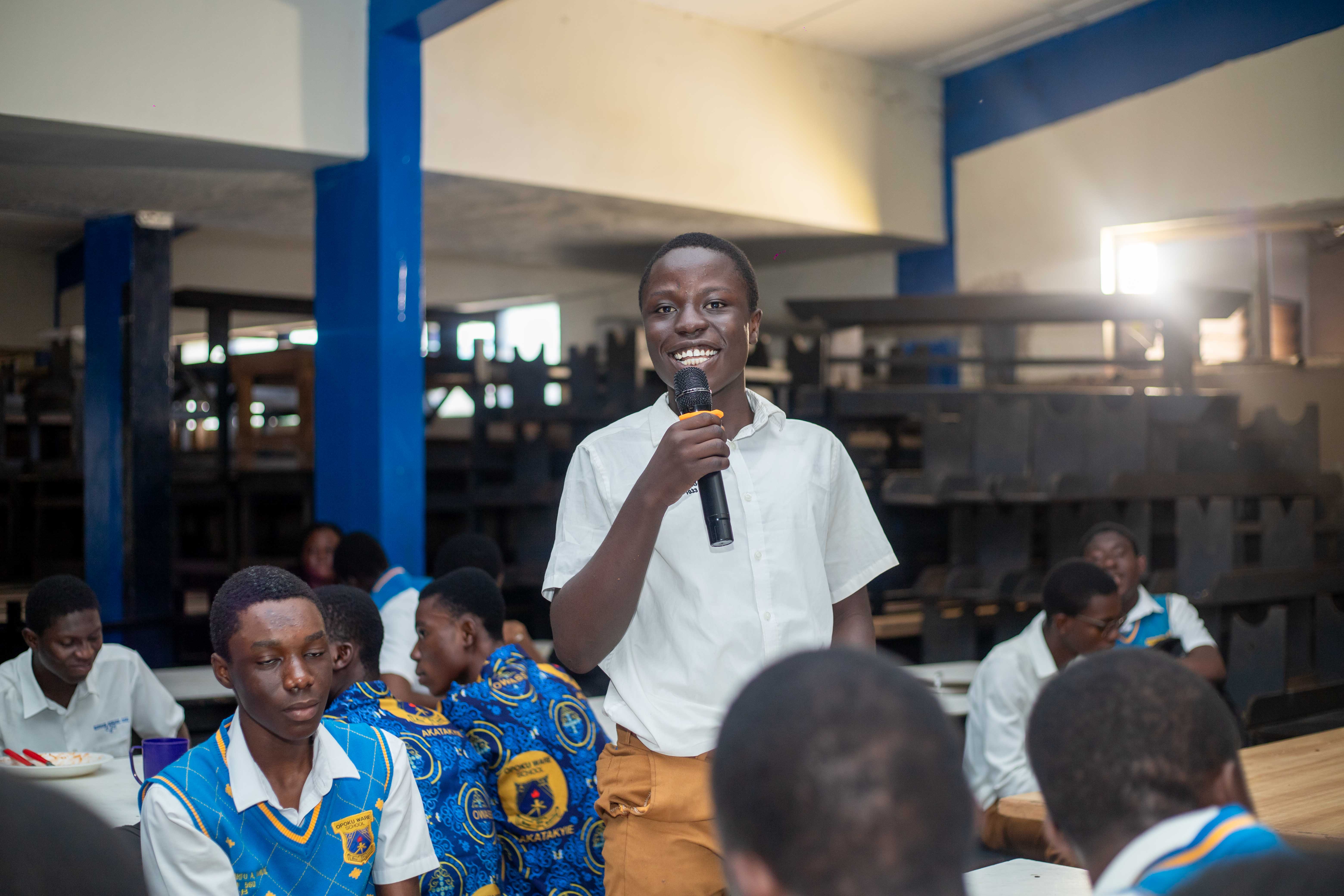 A student addressing peers in a school hall during a screening session