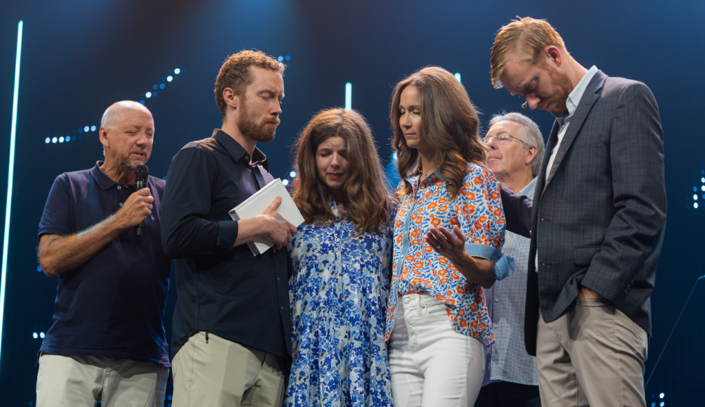 Church members praying together on stage