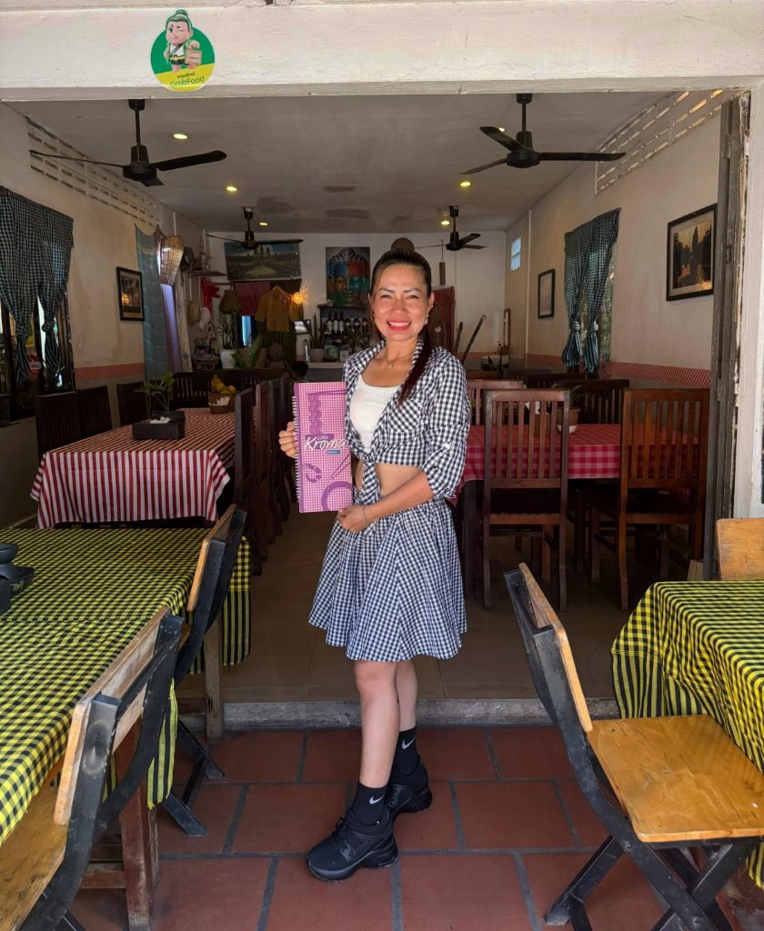 Owner of Little Kroma Restaurant standing in the dining room