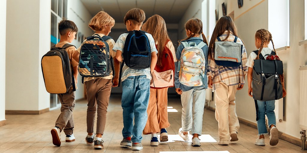Kinder laufen durch einen hellen Schulflur