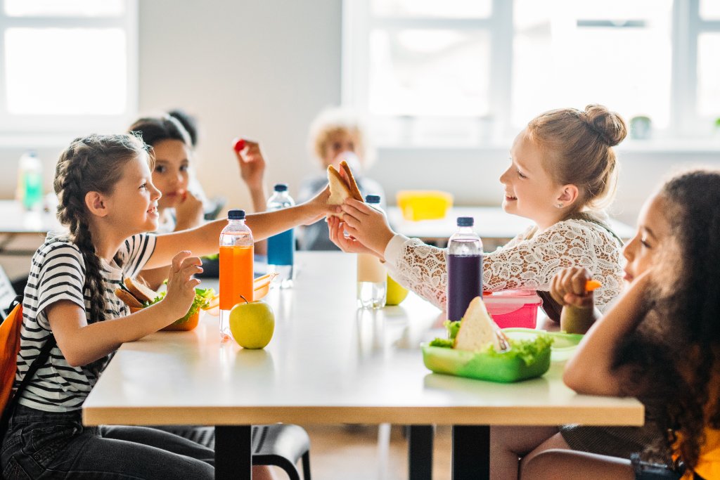 Schülerinnen essen gemeinsam in der Schulkantine