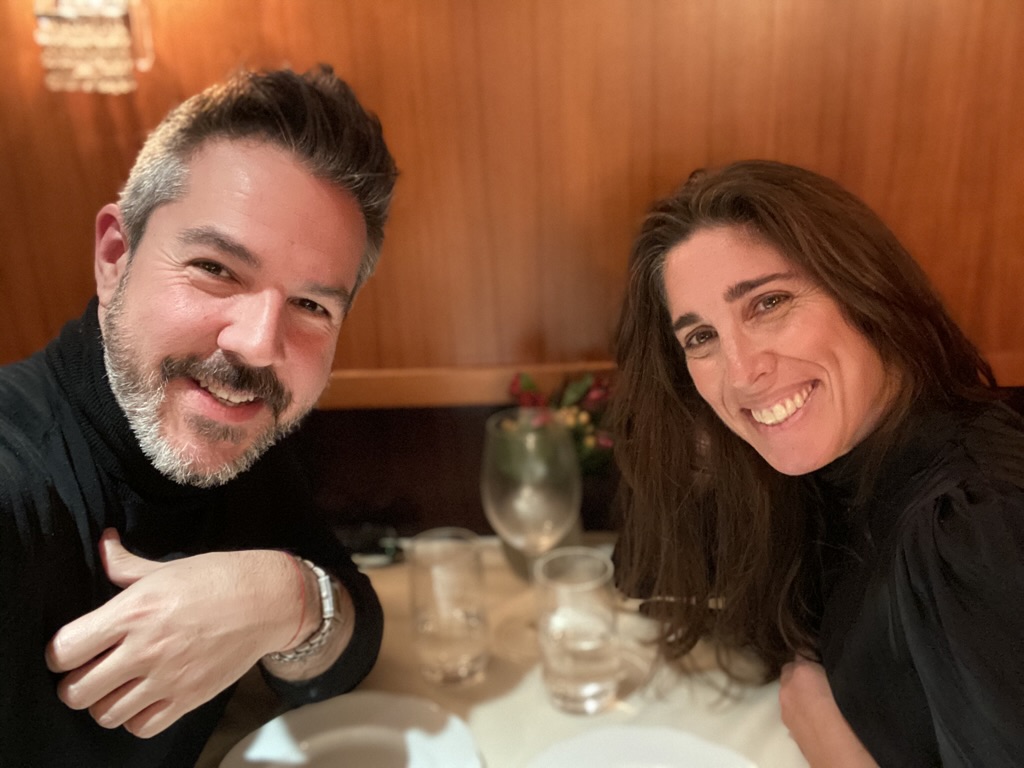 Daniel and Marcy, smiling together at a candlelit dinner table