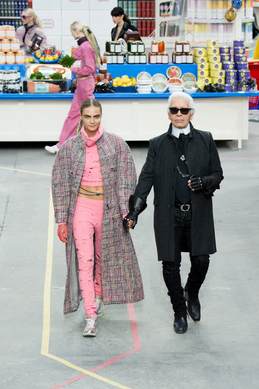 Karl Lagerfeld walks hand in hand with Cara Delevingne through the Chanel supermarket installation