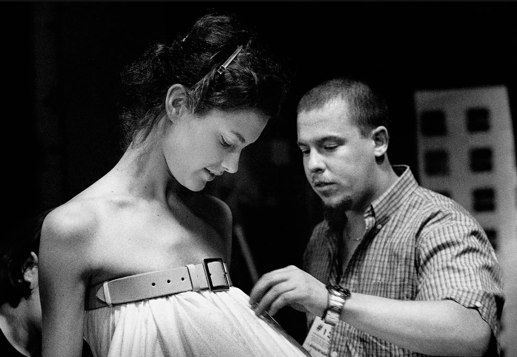 Alexander McQueen adjusts Shalom Harlow's white dress backstage