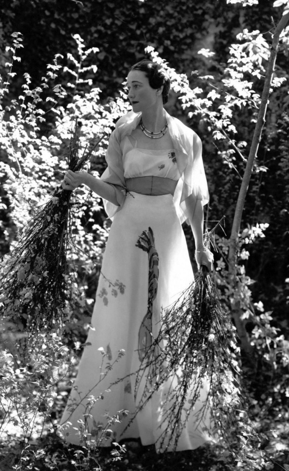 Elsa Schiaparelli's 1937 Lobster Dinner Dress, a light evening gown printed with an oversized lobster motif, photographed in a garden setting.