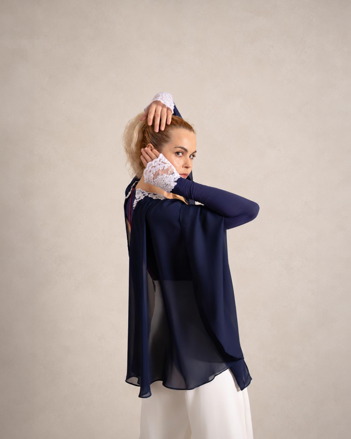 El Abanico — sheer navy chiffon cape and white lace cuffs over white trousers