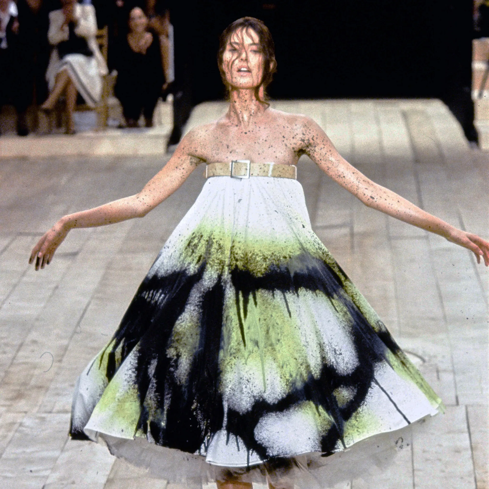 Shalom Harlow presents the white dress covered in black and green paint after the robotic performance