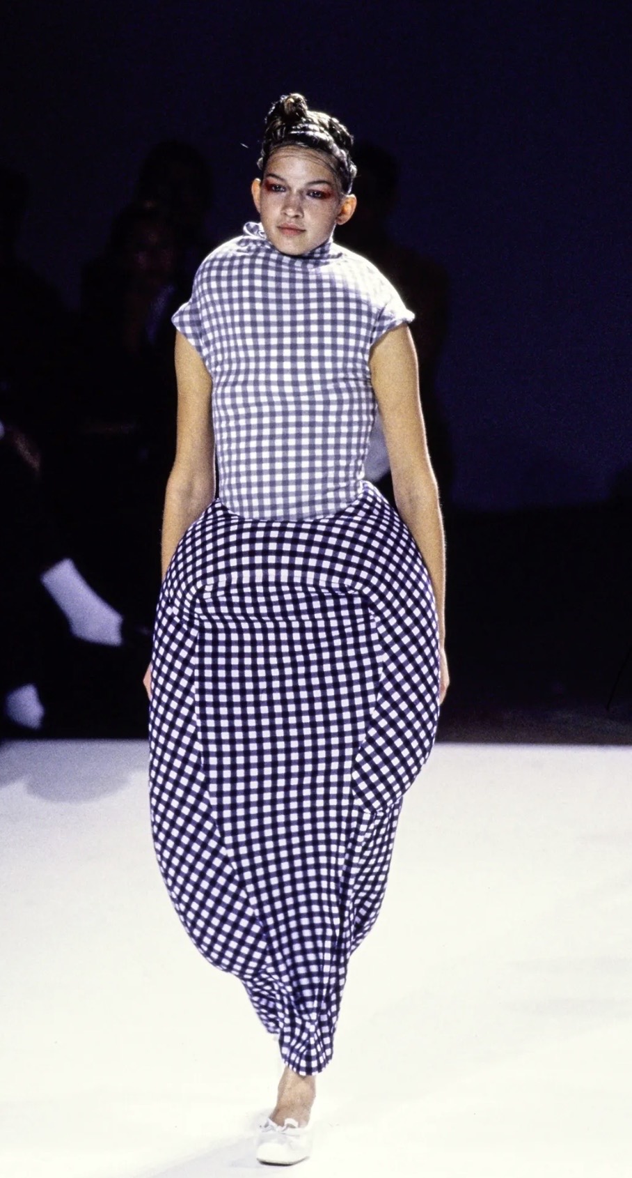 Comme des Garçons Spring/Summer 1997 blue-and-white gingham dress with a voluminous padded cocoon silhouette, worn by a model on the runway.