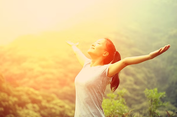 Woman with arms outstretched in golden sunlight