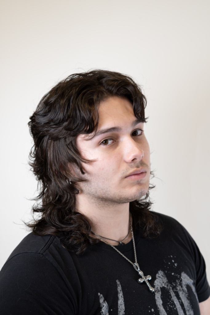 Three-quarter portrait of a dark wavy mullet with layered volume