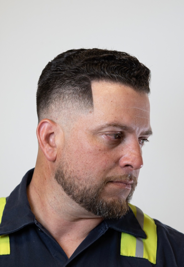 Sharp mid-to-high skin fade with a defined temple line-up and goatee