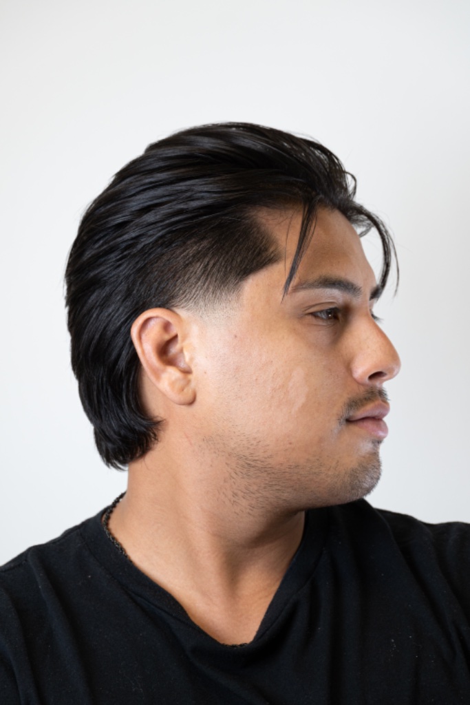Modern wolf cut with taper fade, styled with a groomed mustache and beard