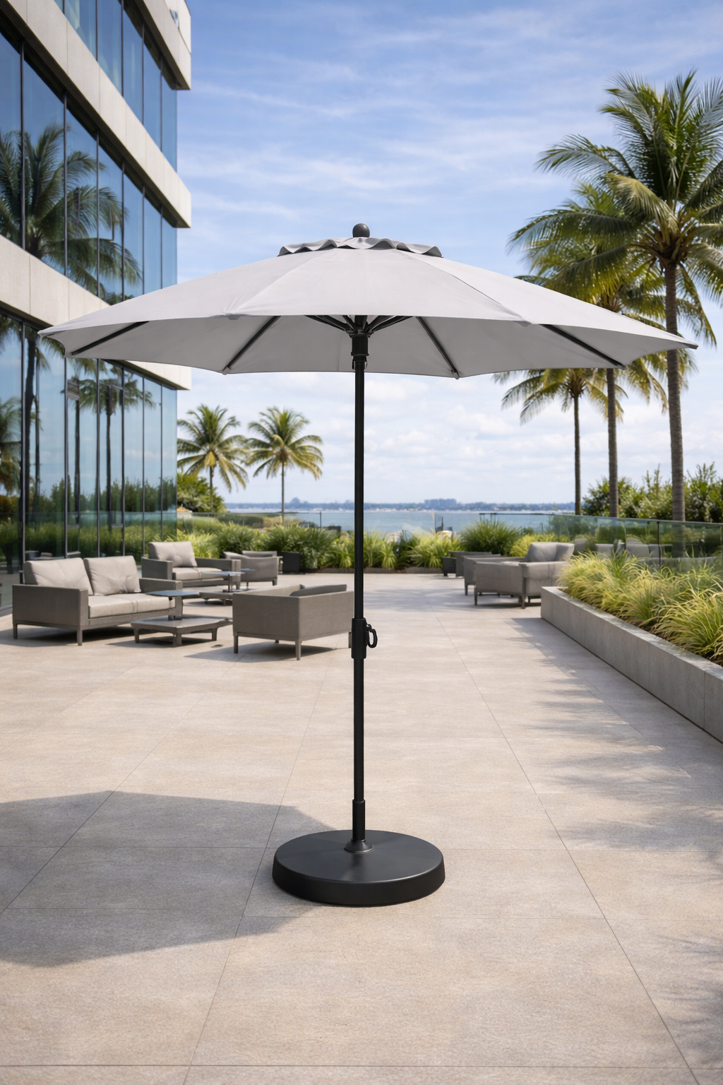 Sombrilla de poste central instalada en una terraza con mobiliario exterior