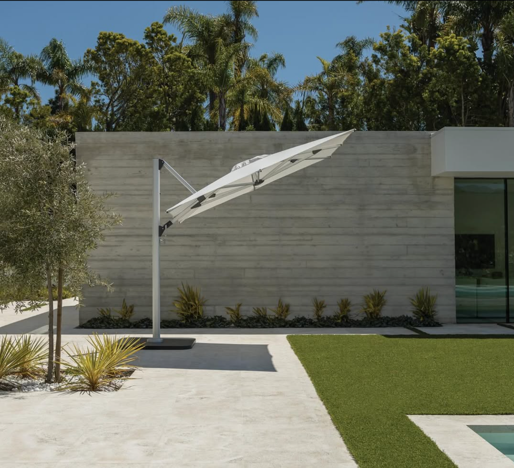 Sombrilla cantilever en patio minimalista con muro de concreto