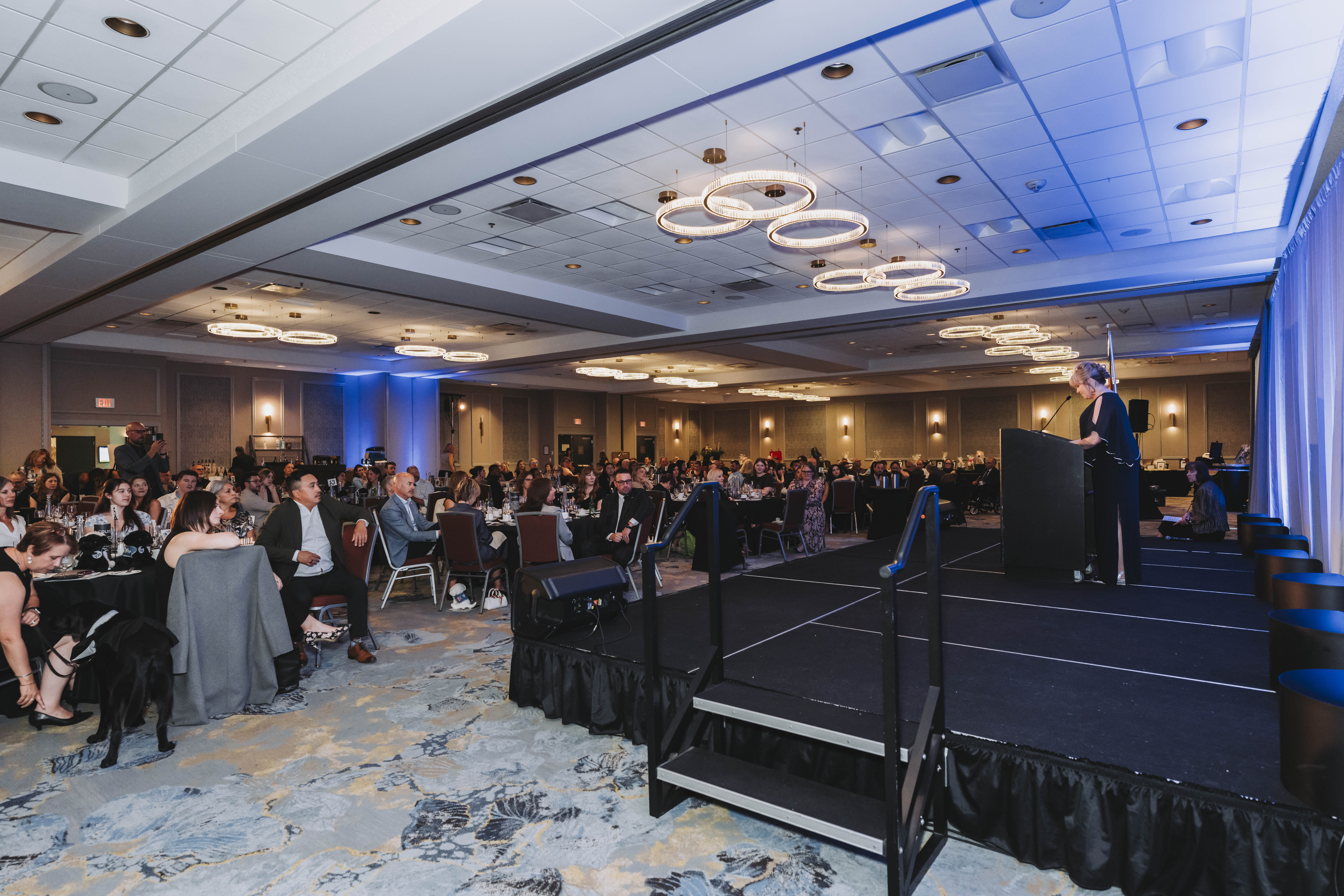 A wide view of the ballroom and stage during the gala