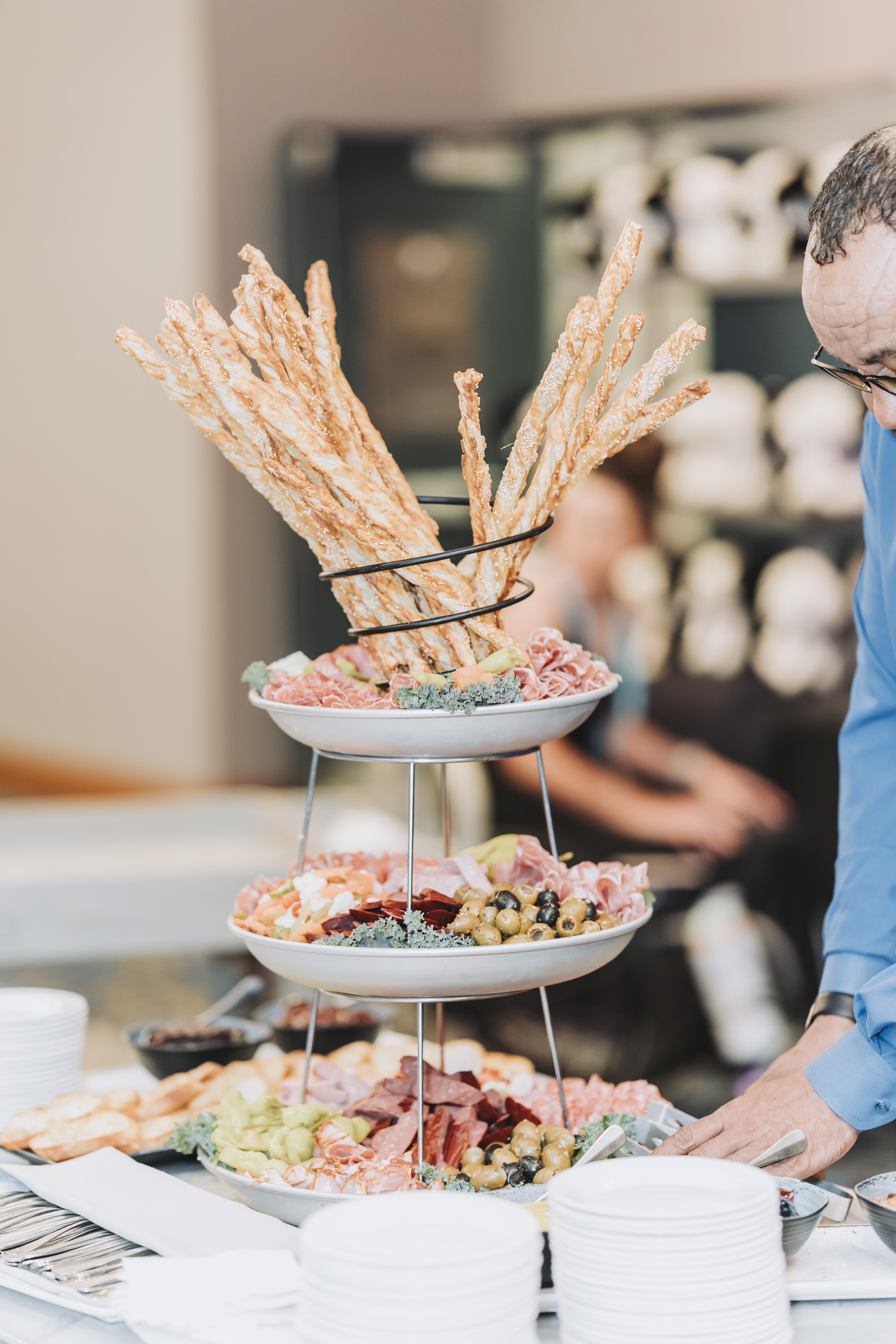 A tiered stand of breadsticks and charcuterie at the reception