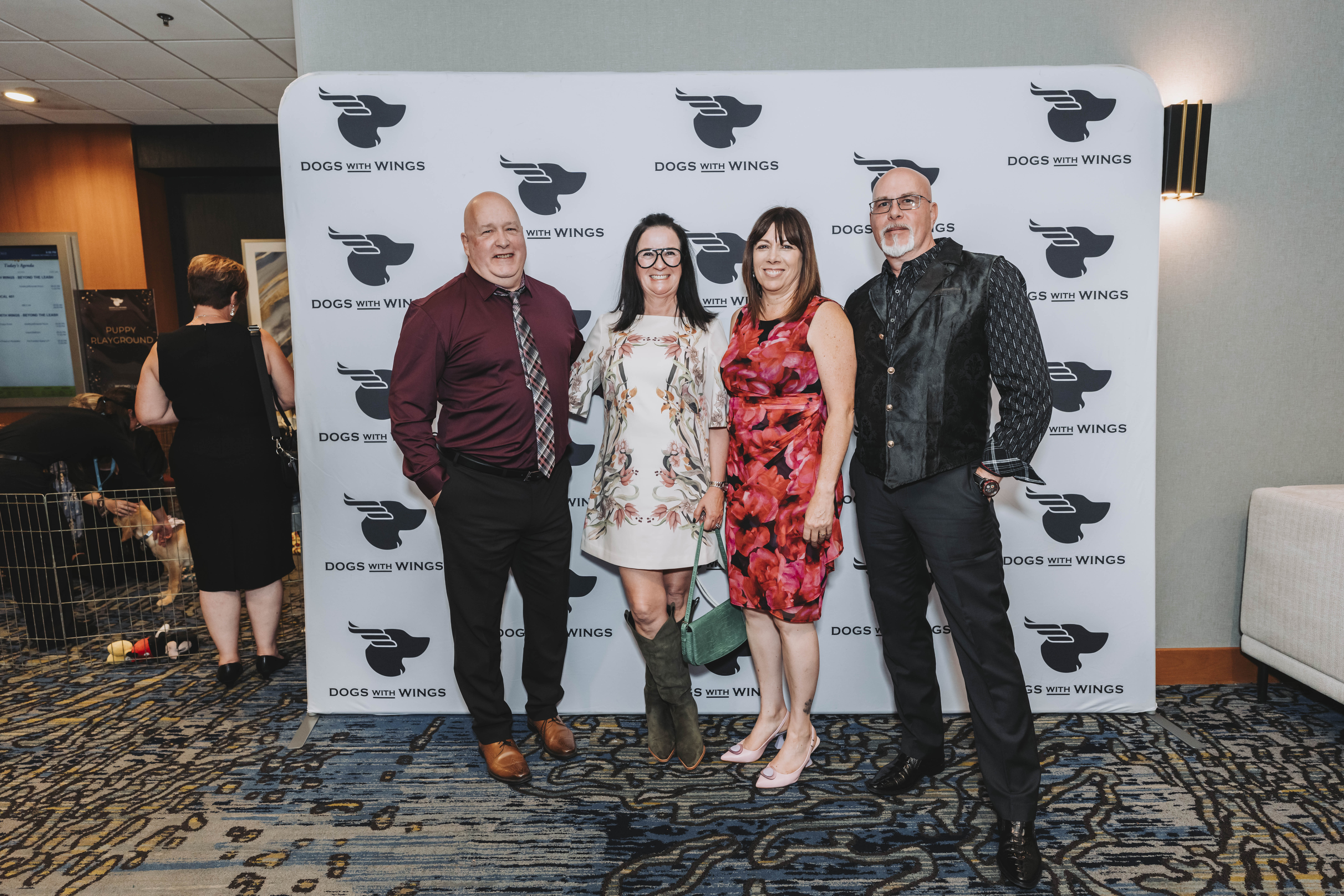 Four guests posing together at the gala step-and-repeat