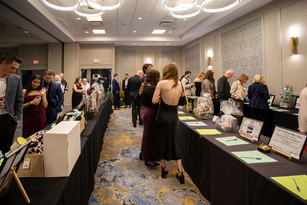 Gala 2025 silent auction tables with guests browsing