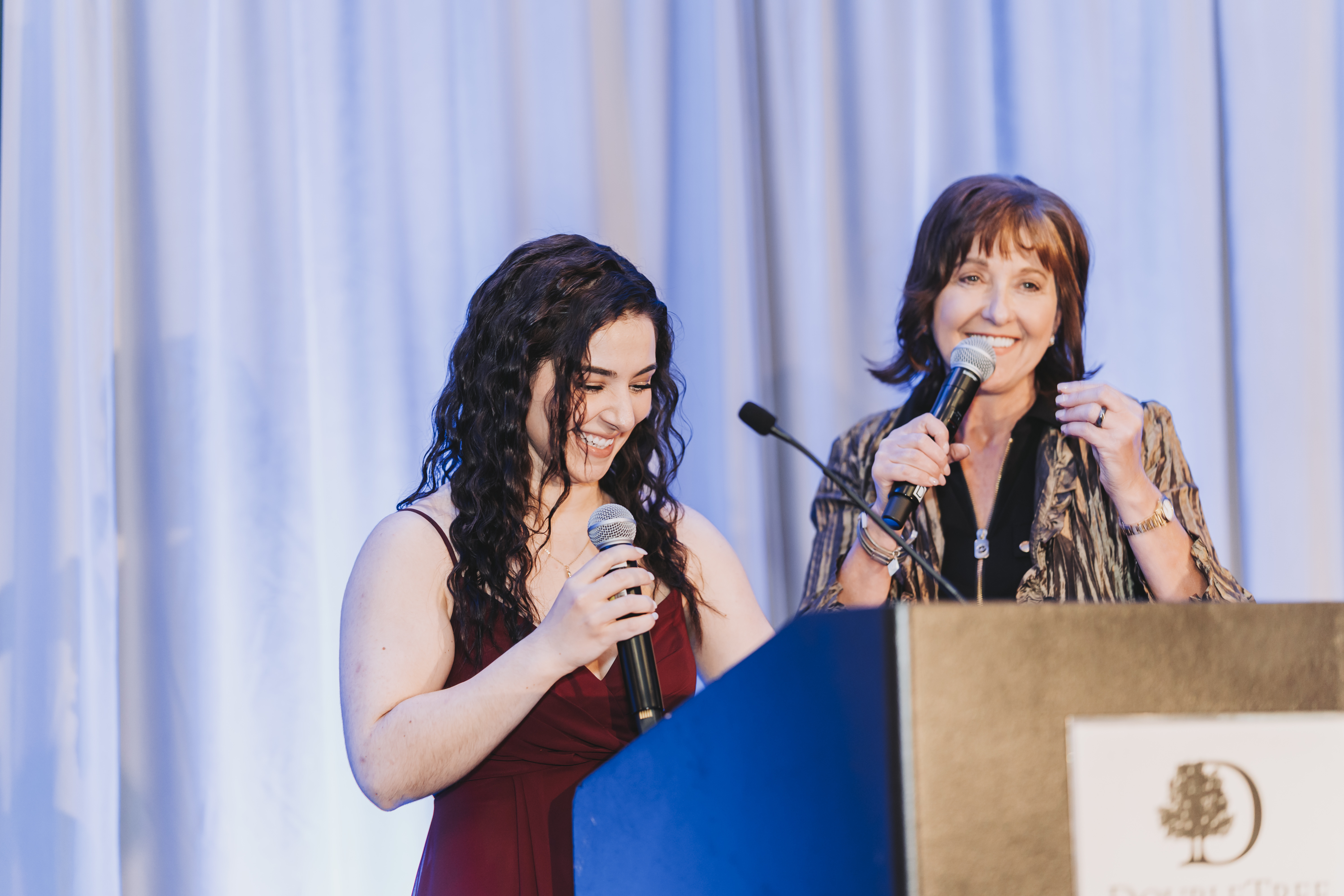 Two guests speaking together at the gala podium
