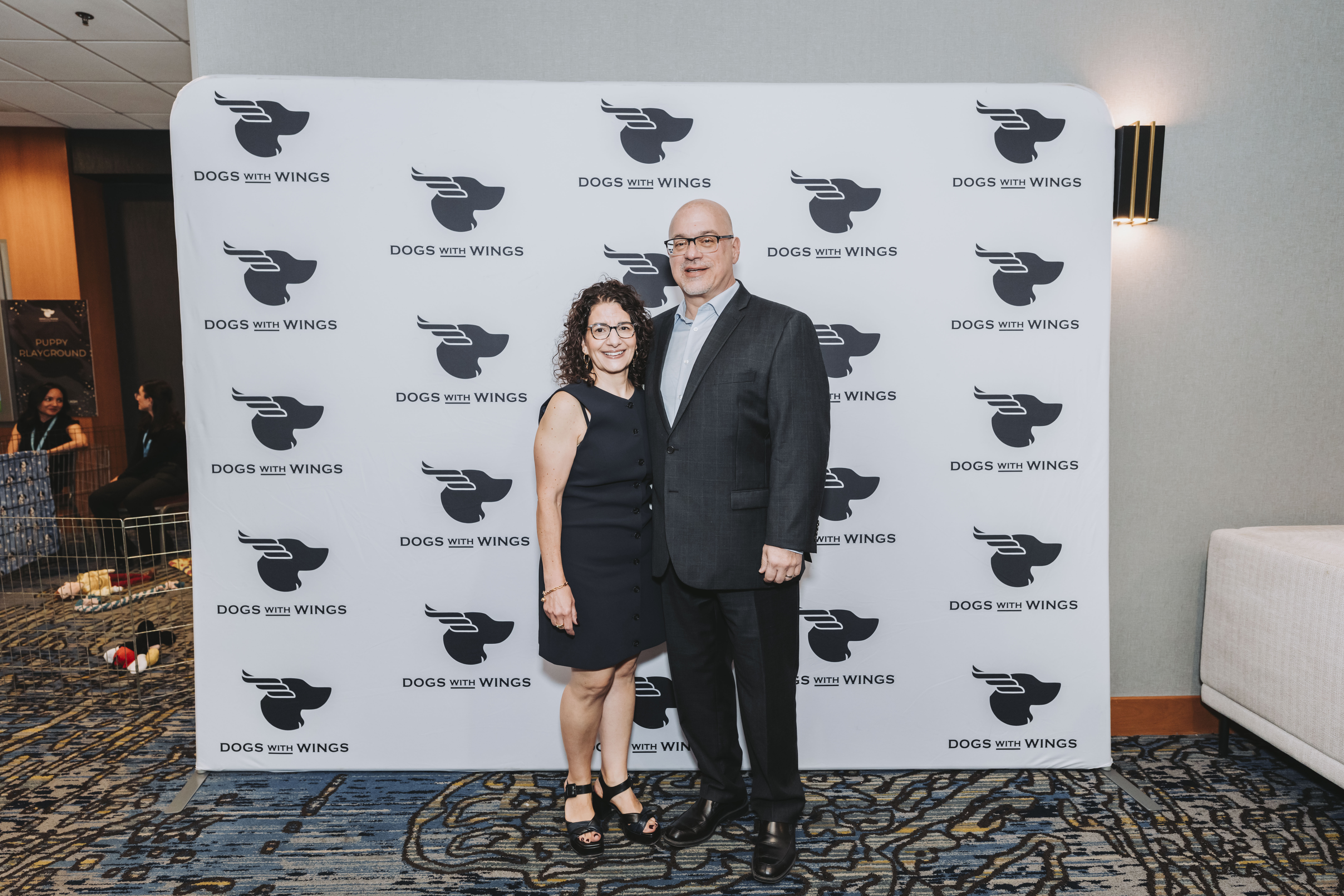 Two guests smiling together at the gala photo wall