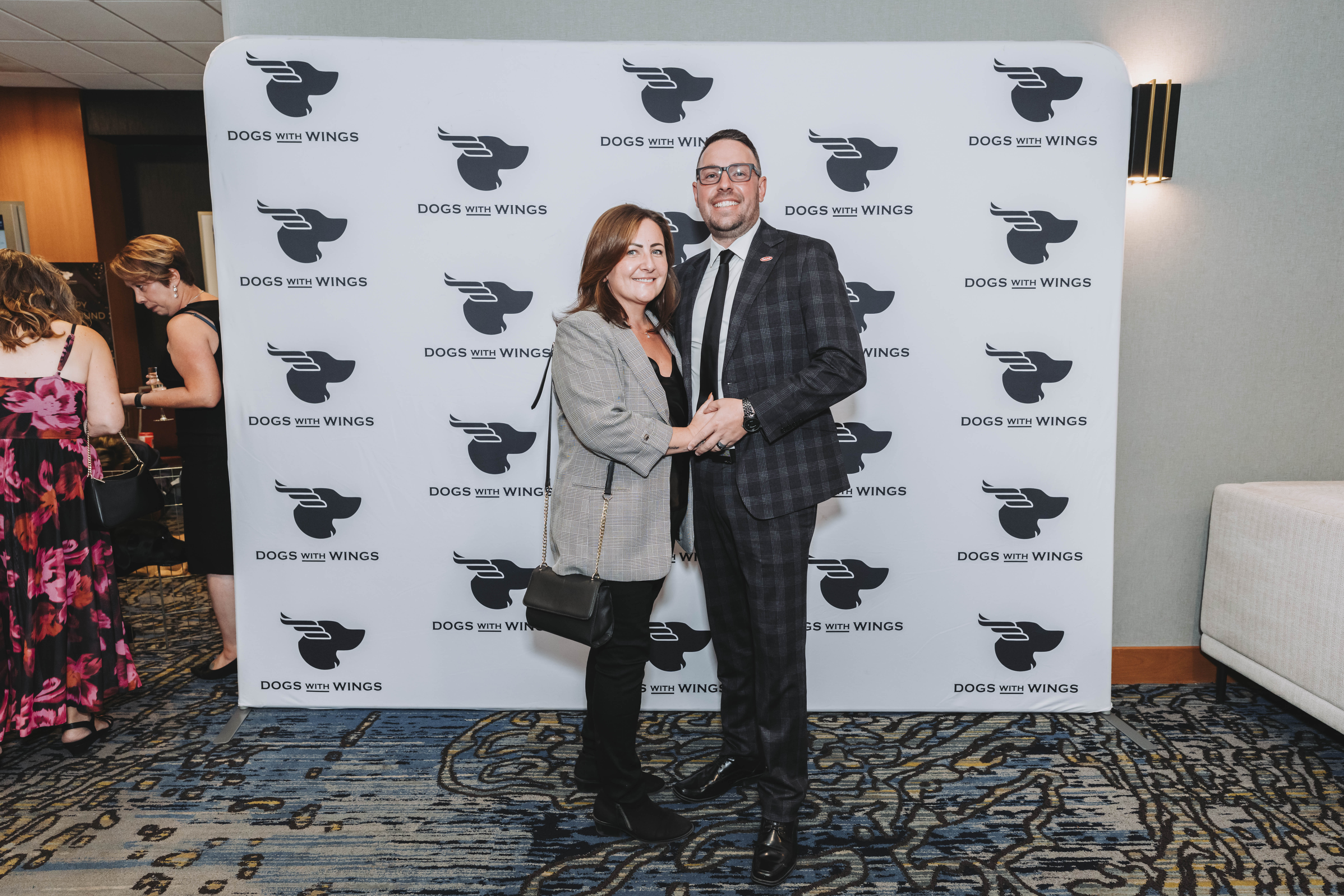 A couple in plaid posing at the gala photo wall