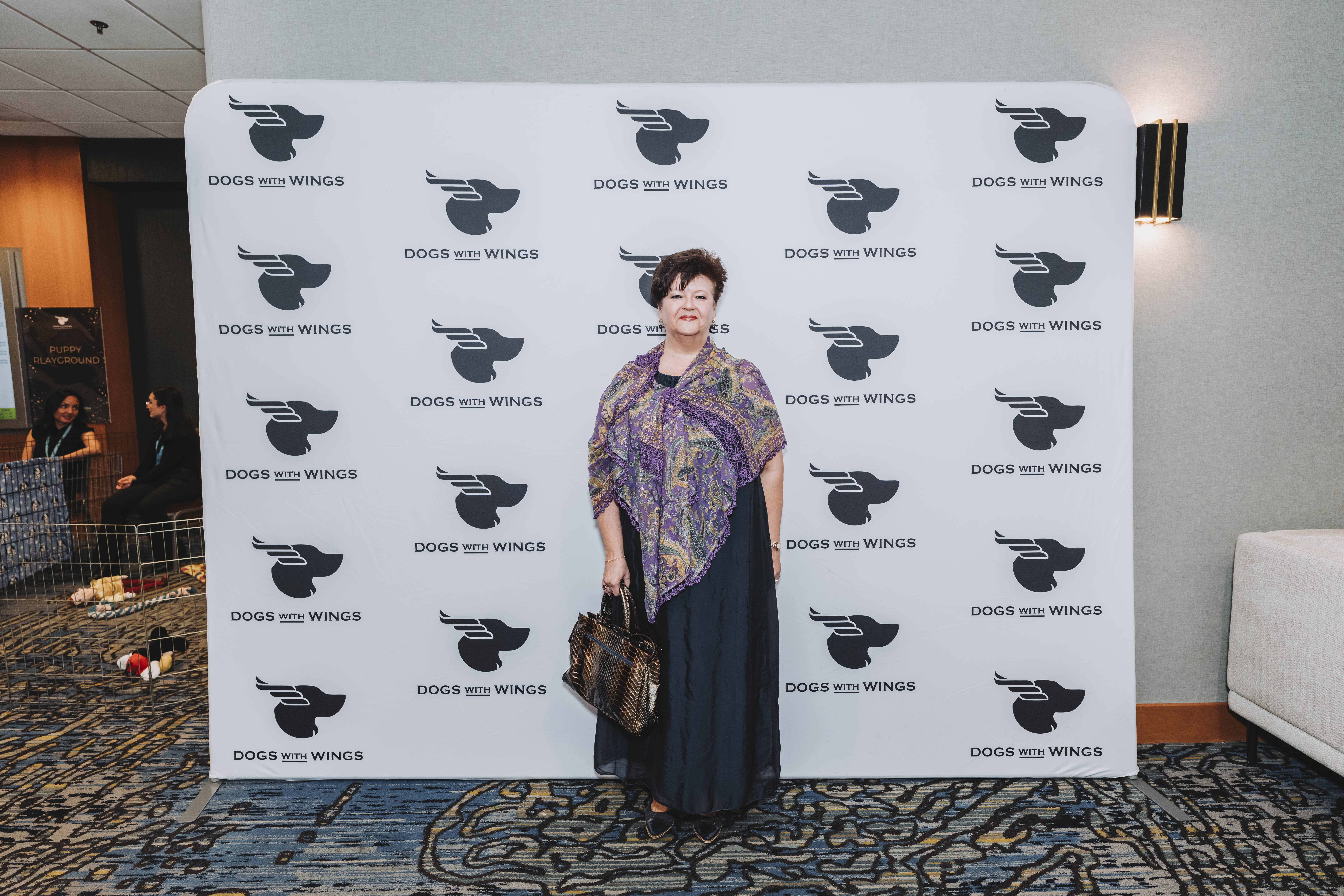 A guest in a colourful shawl posing at the gala backdrop