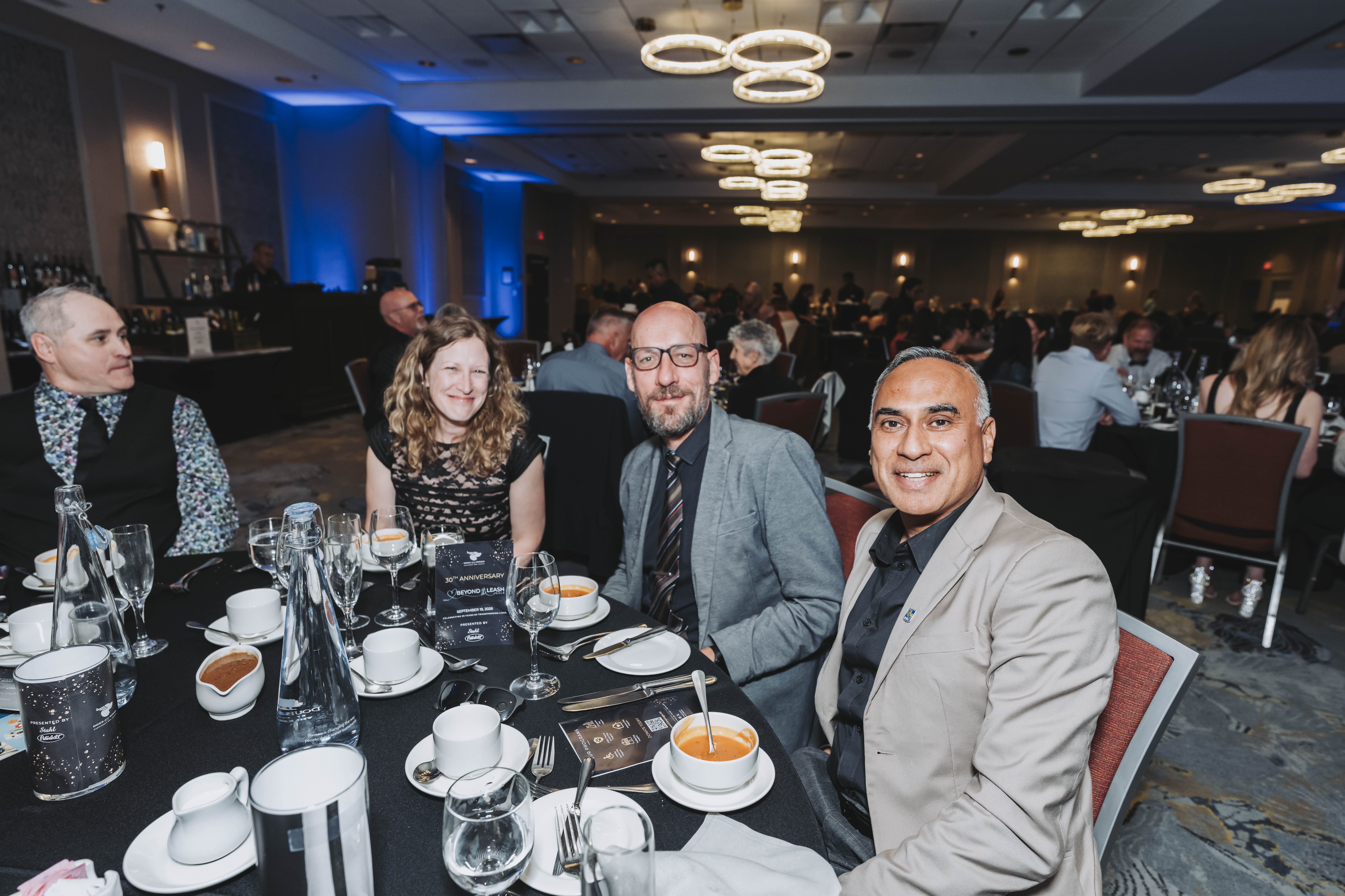 Four guests smiling at their table during the gala dinner
