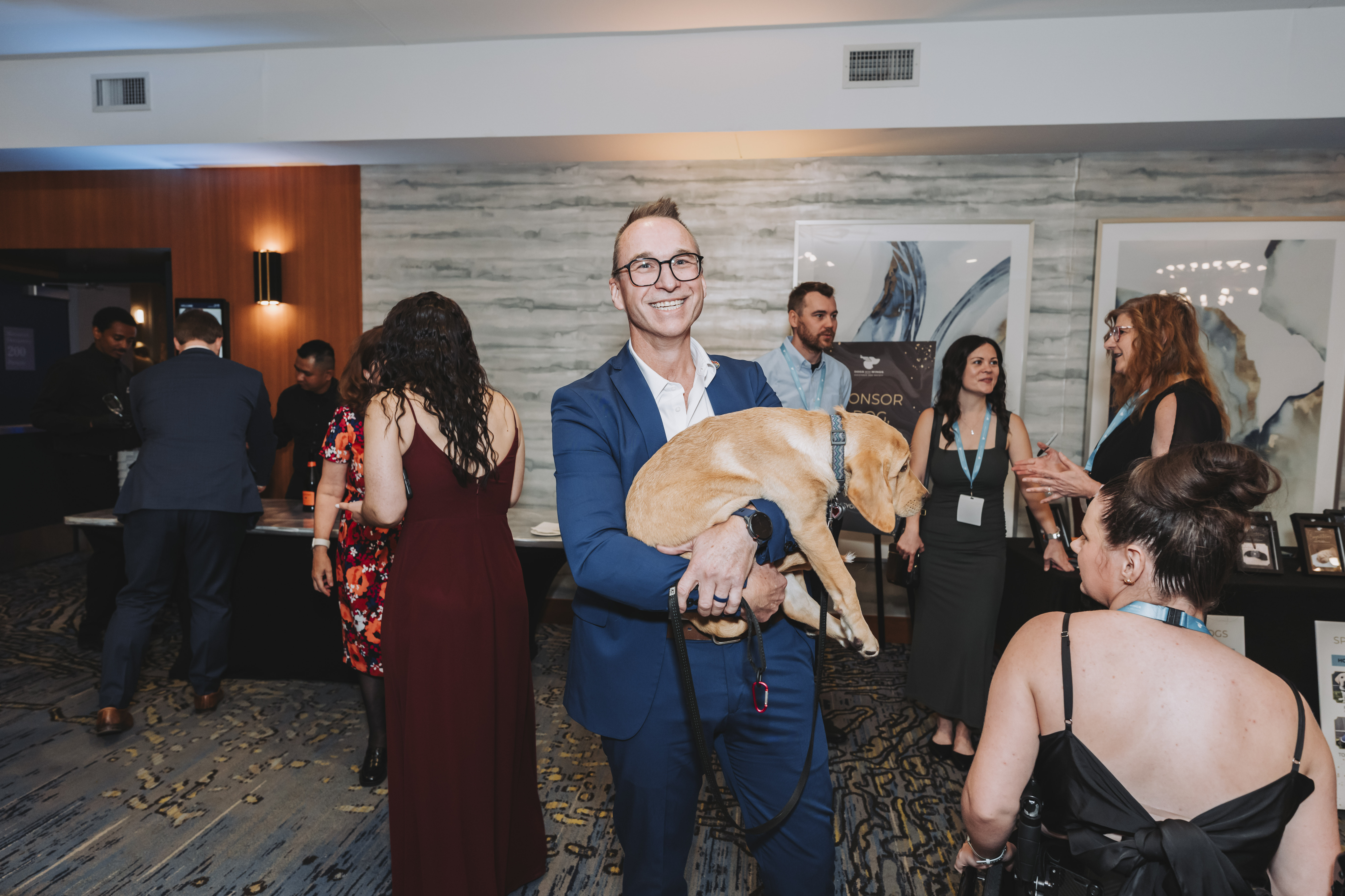 A guest holding a yellow Labrador puppy at the reception