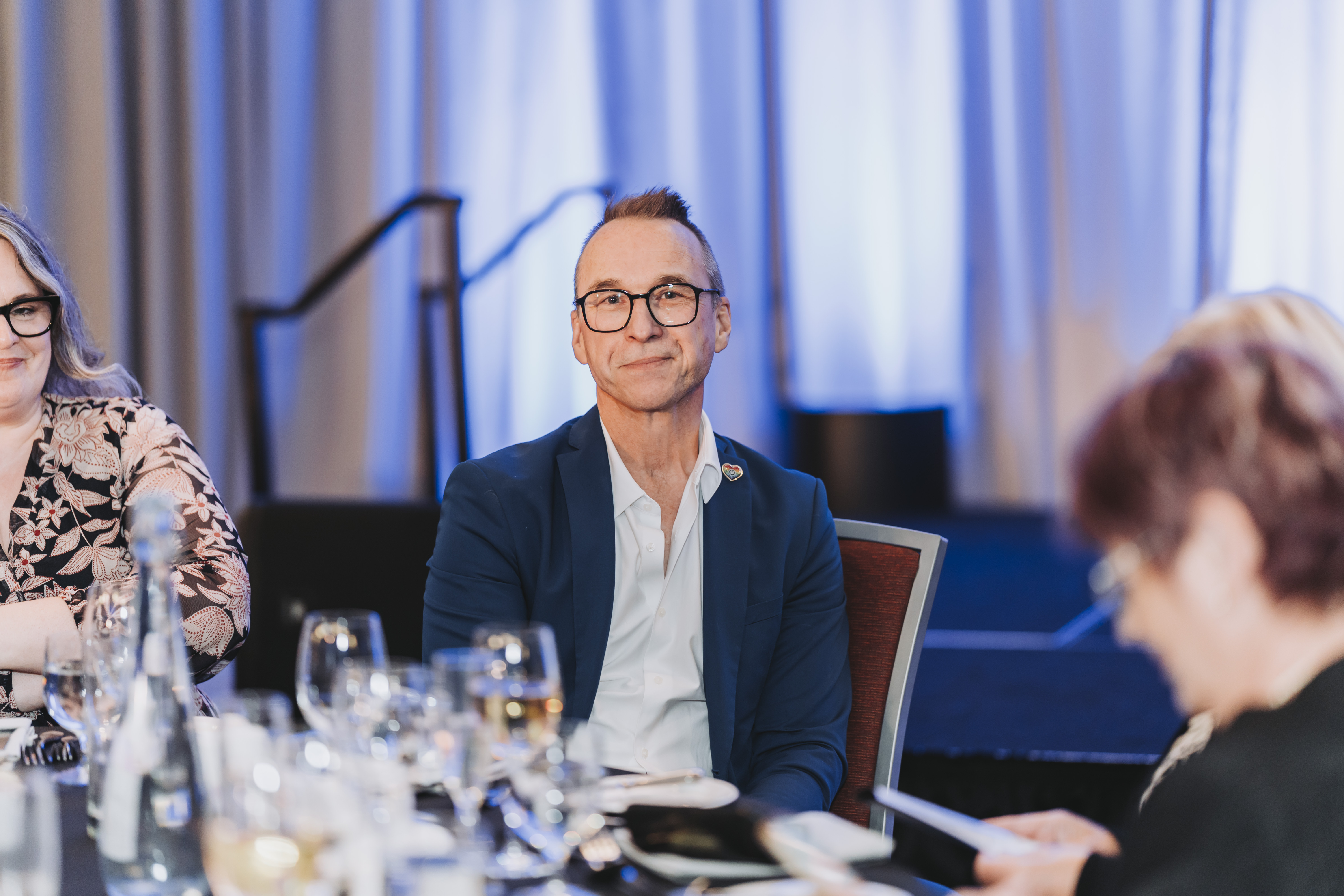 A guest seated at a banquet table during the gala