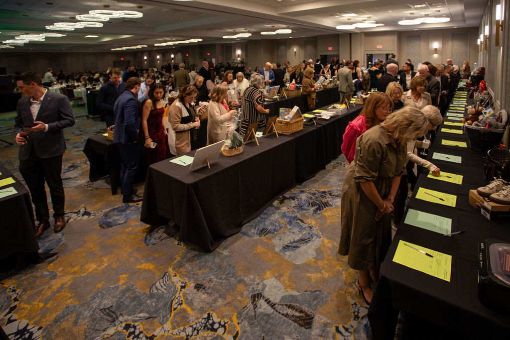 Guests browsing auction tables at Dogs With Wings Gala