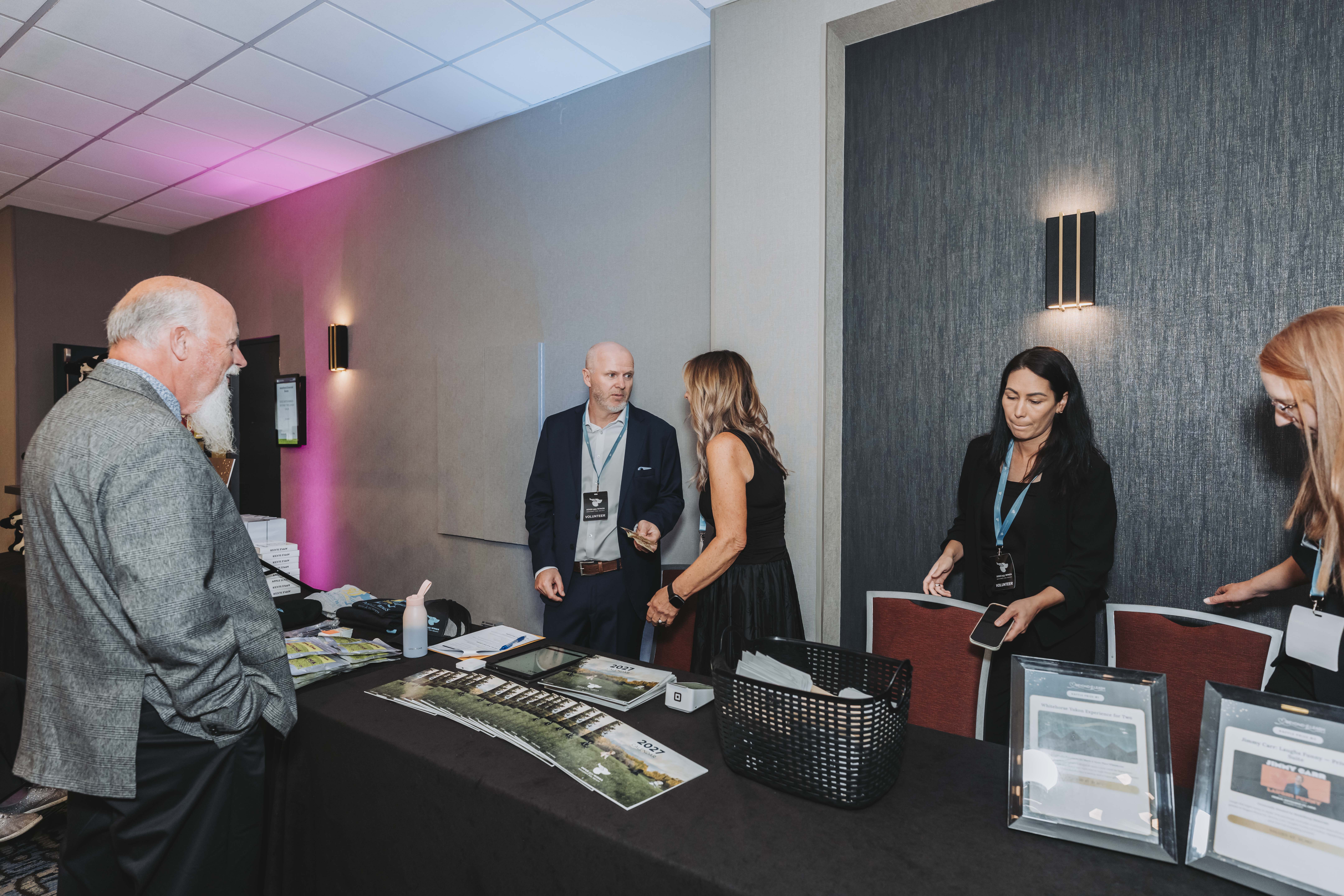 Guests and volunteers talking at the registration and information desk