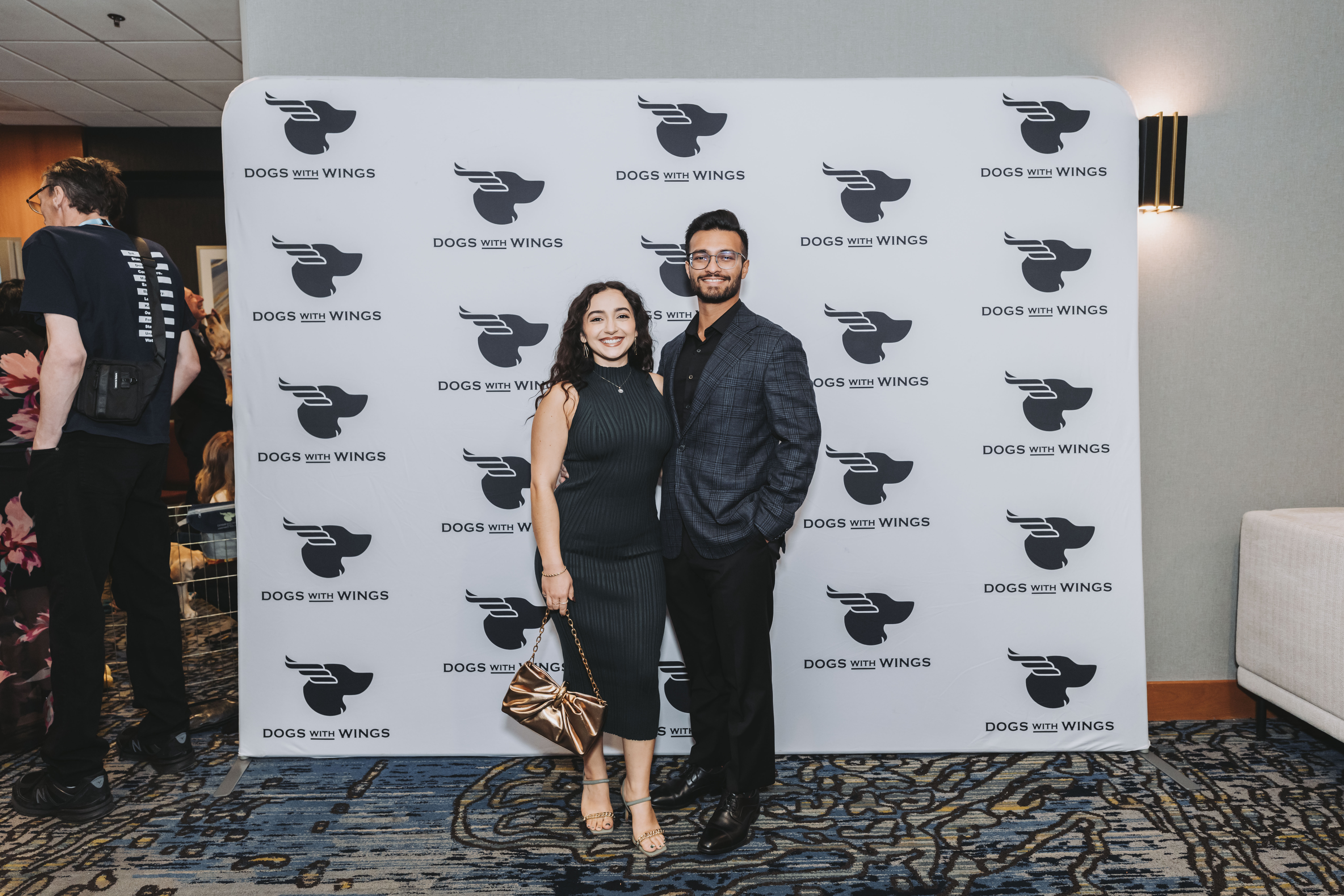A couple in black and blue posing at the backdrop