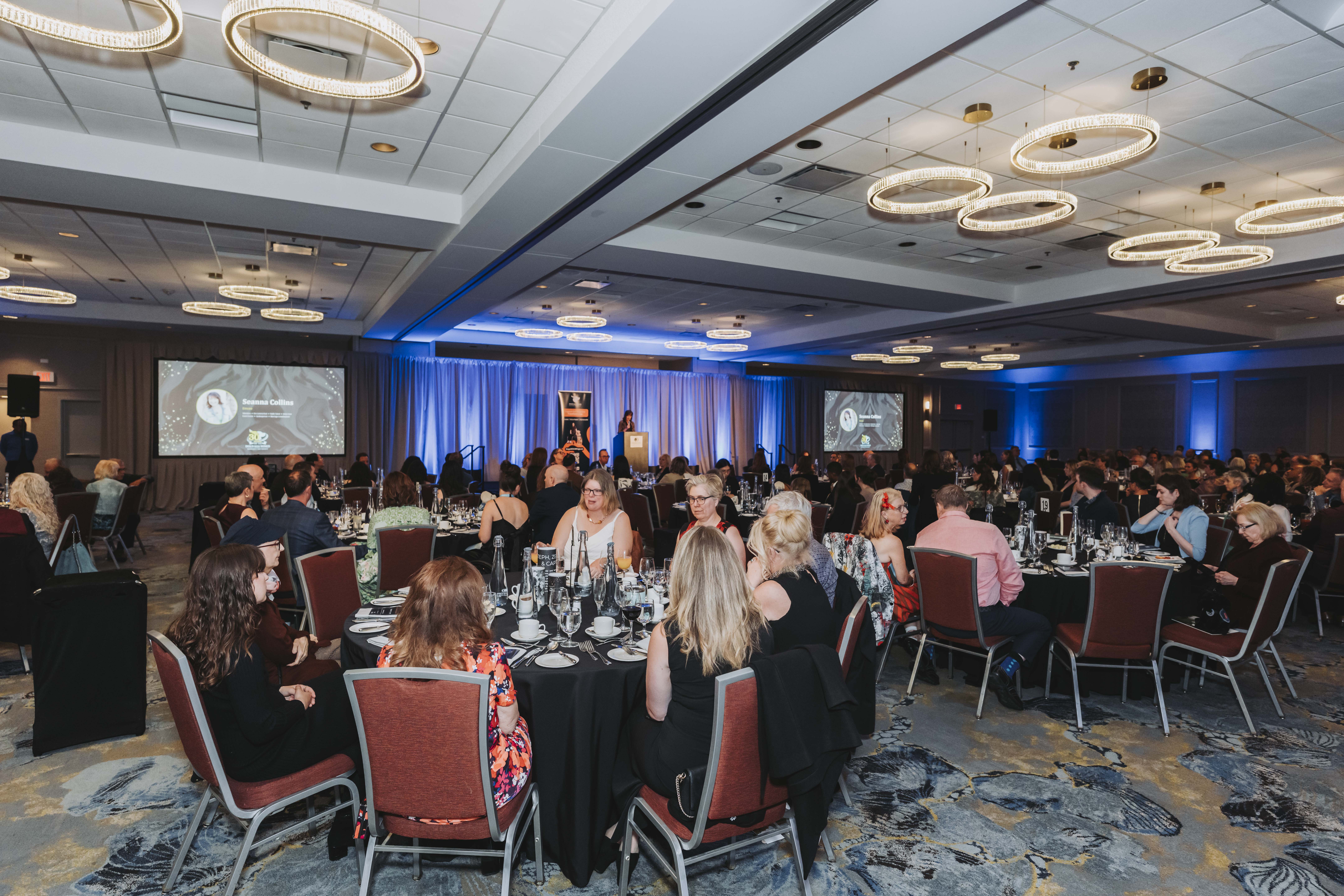 A wide view of the ballroom during a tribute on the gala screens