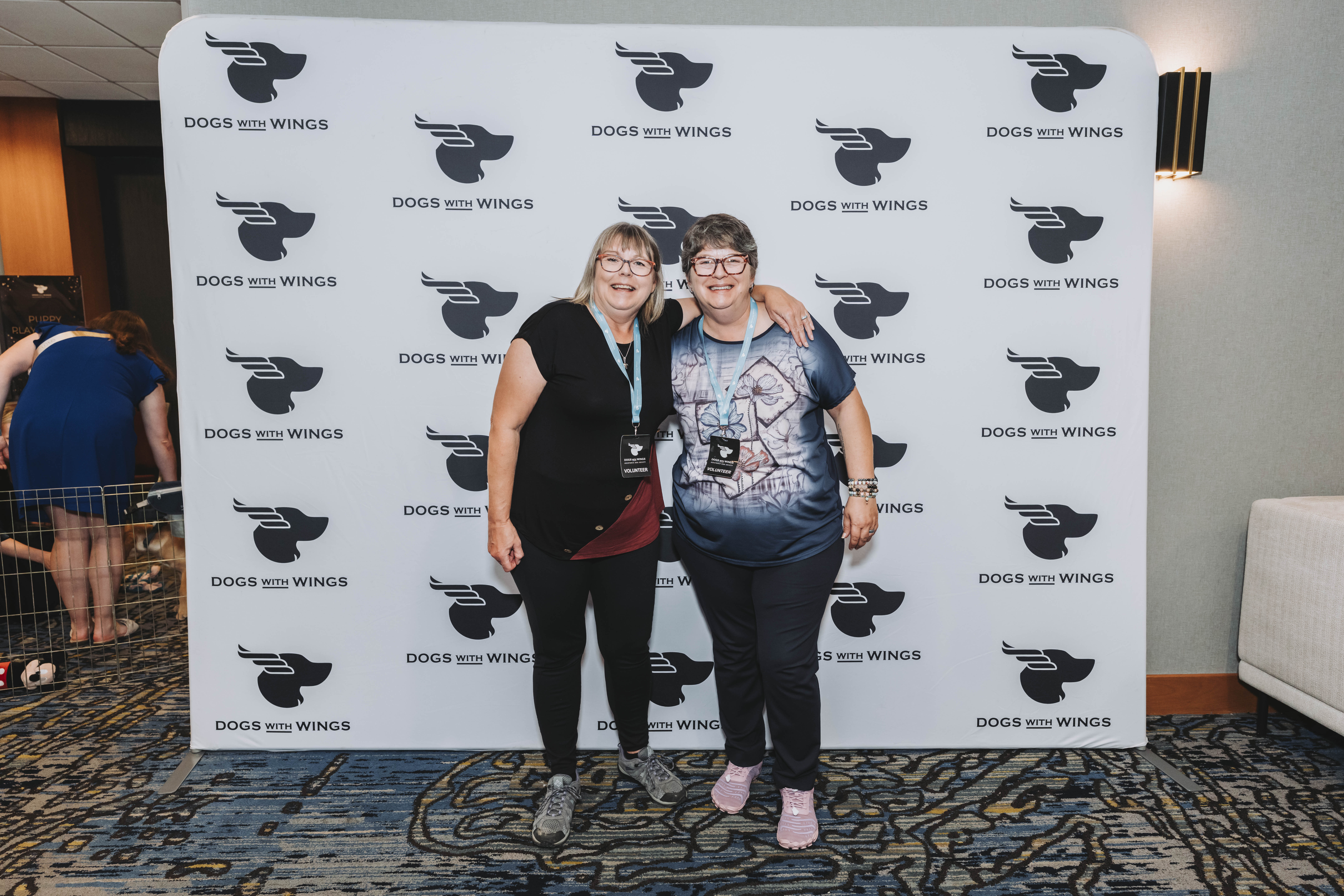 Two volunteers posing together at the gala photo wall