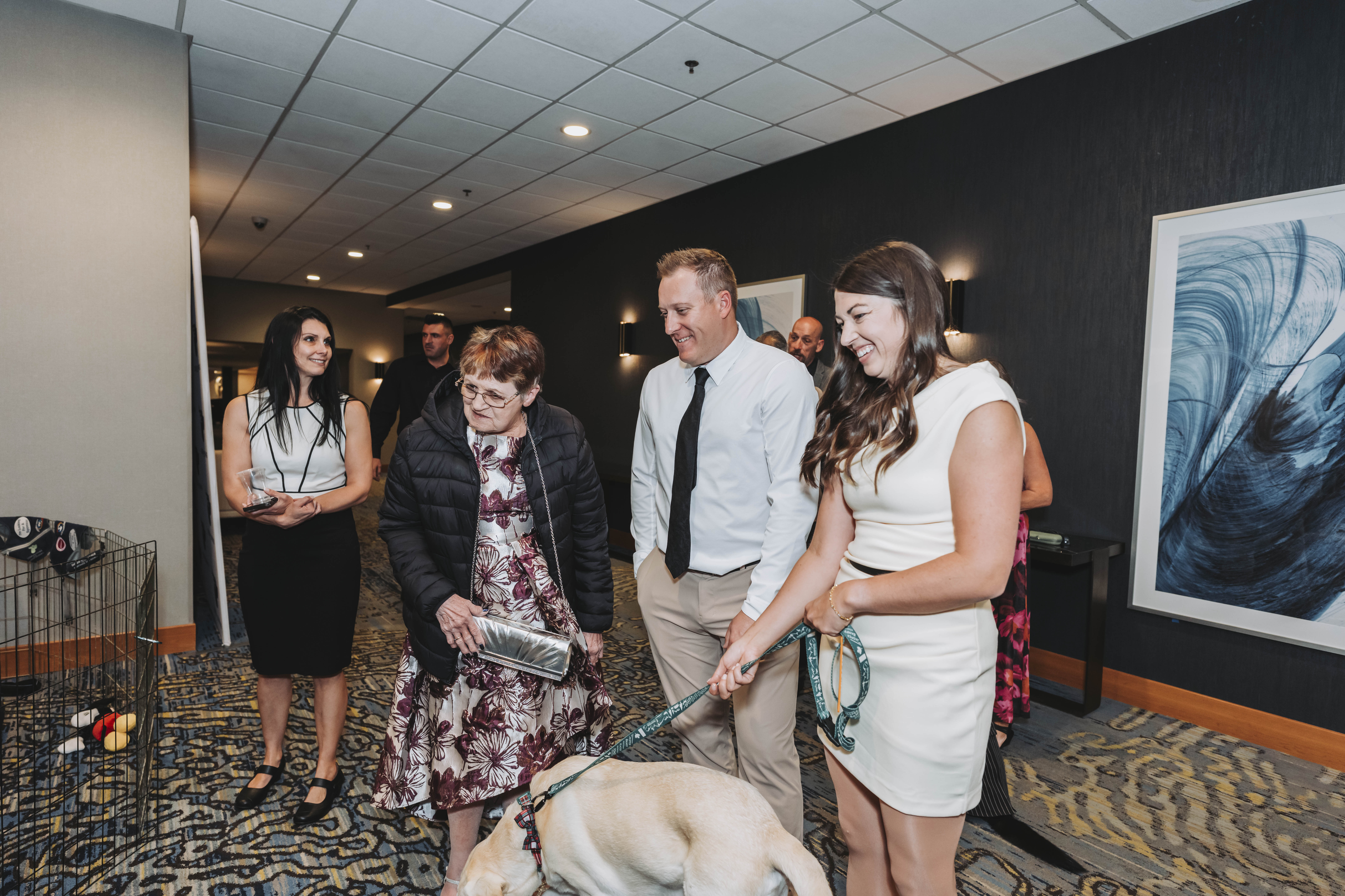 Guests walking a puppy through the gala hallway
