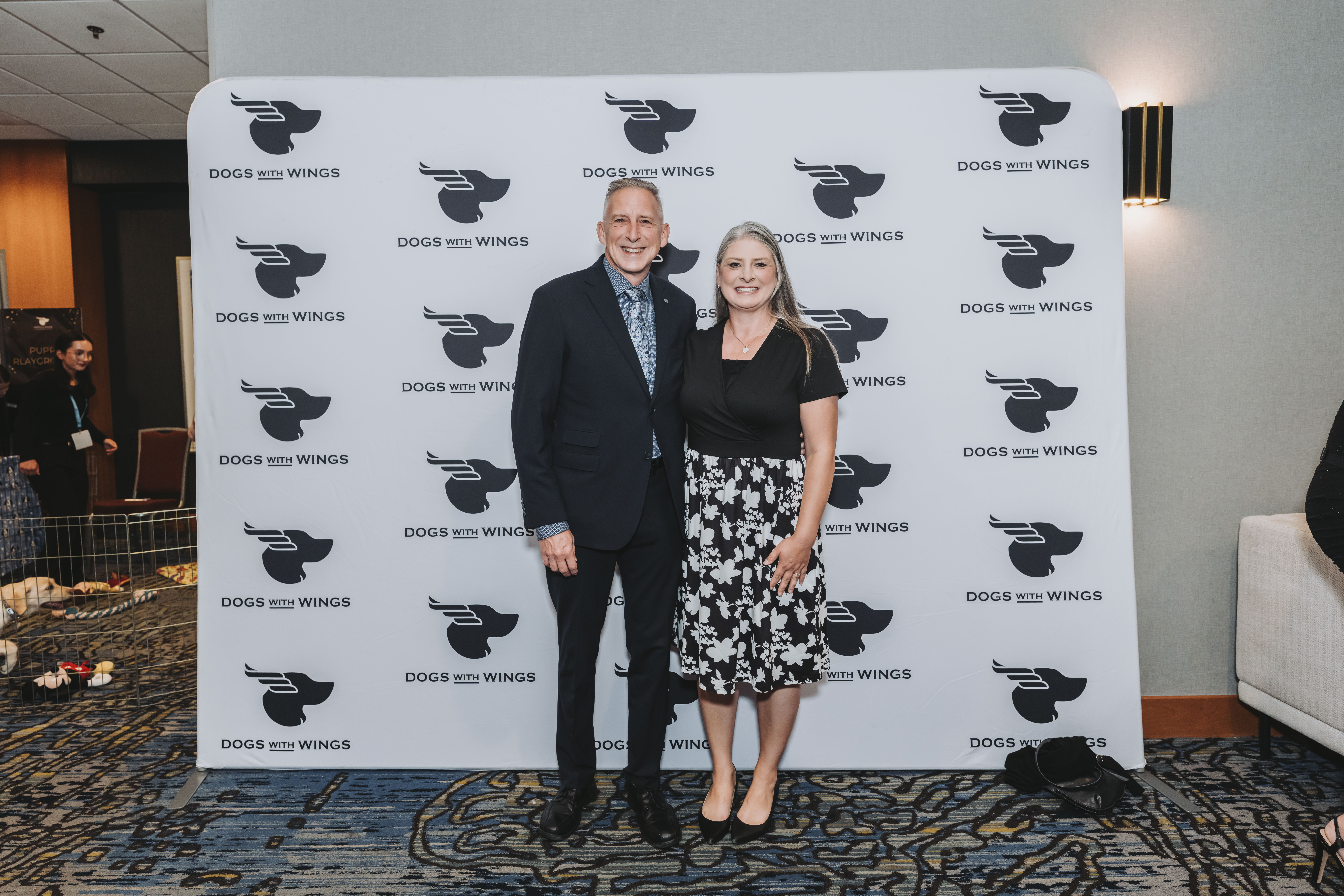 A couple smiling at the gala step-and-repeat