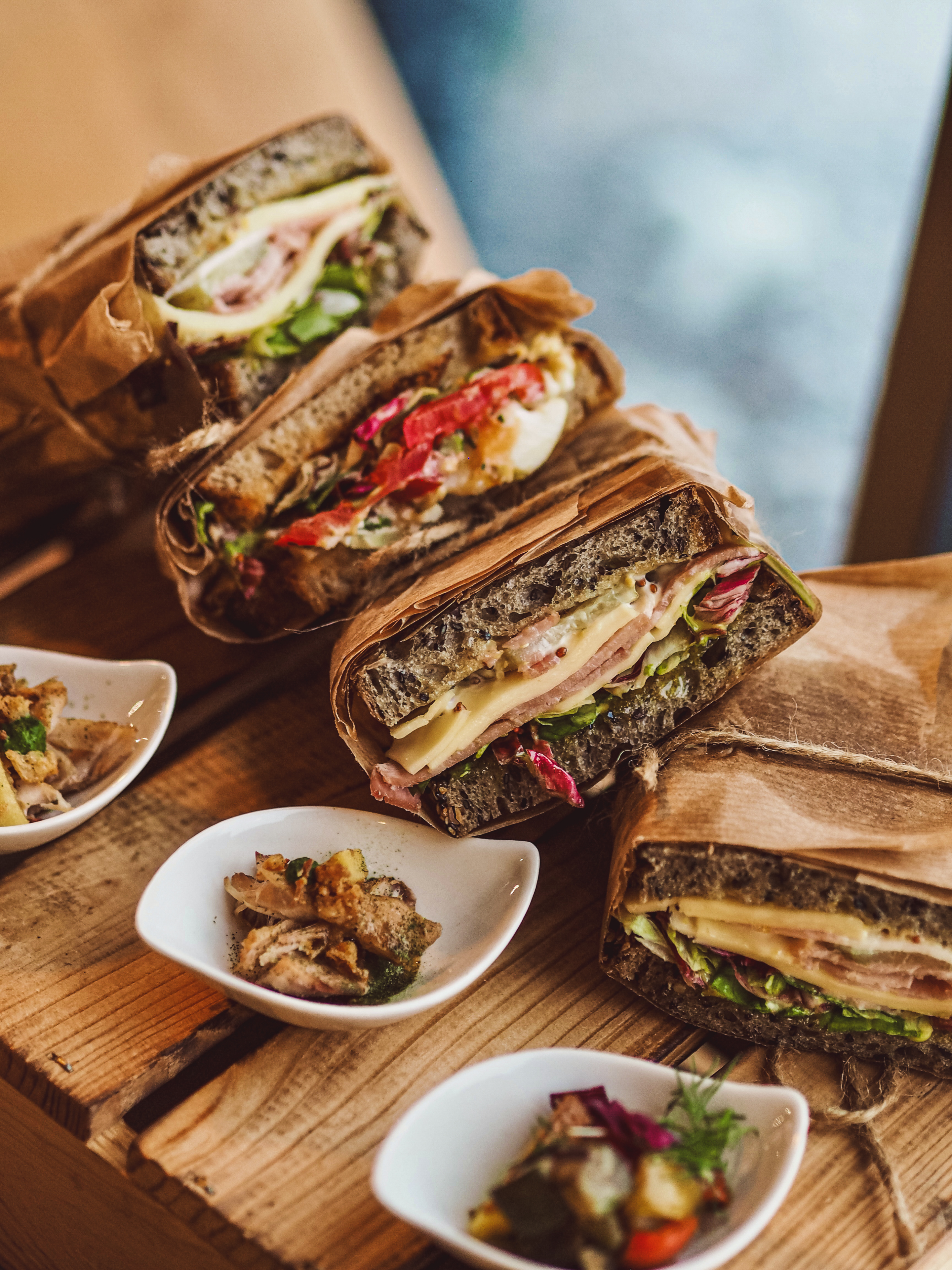 Zabalené sendviče na dřevěném prkně — Bistro Na Chlebu