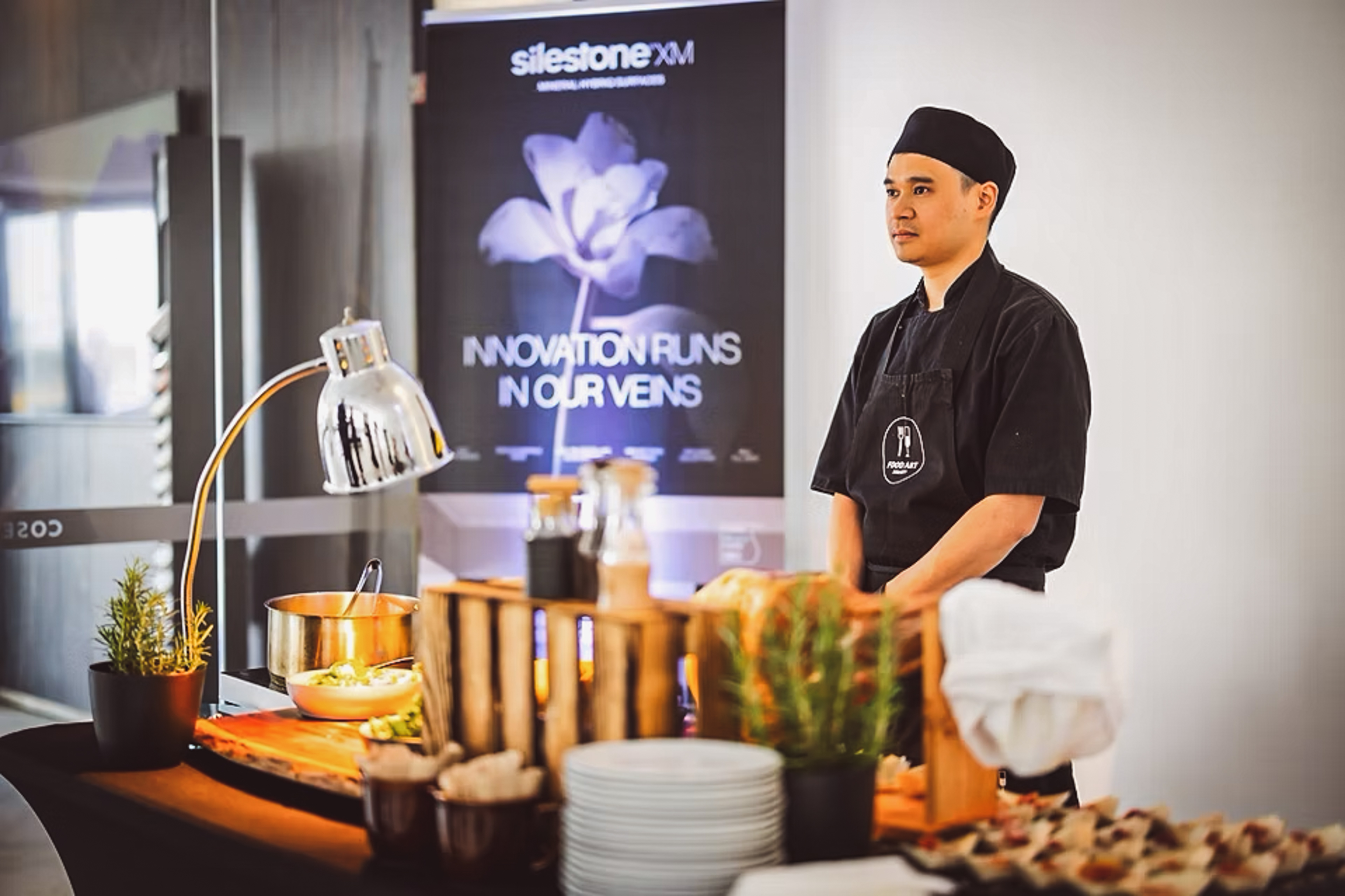 Kuchař FoodART Agency u teplé bufetové stanice na firemní akci