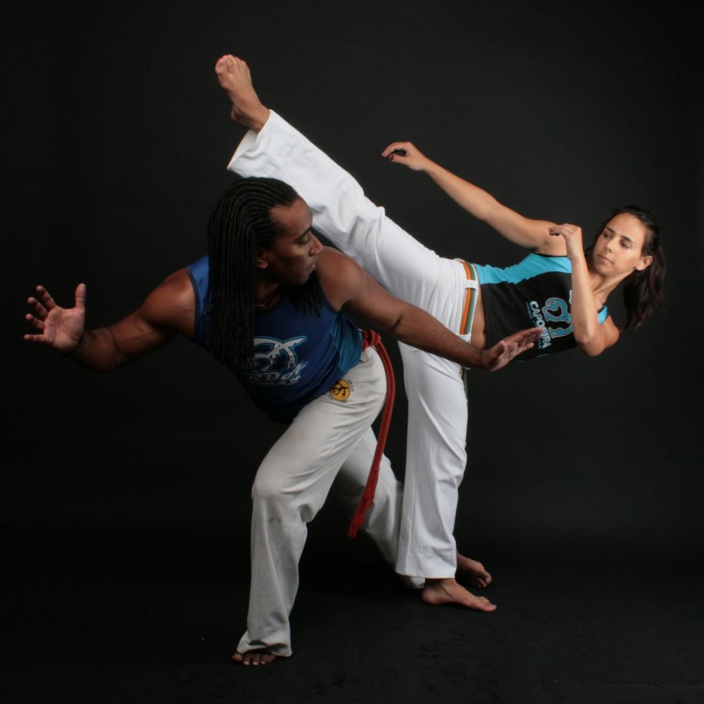 Capoeirista performing in a dimly lit studio
