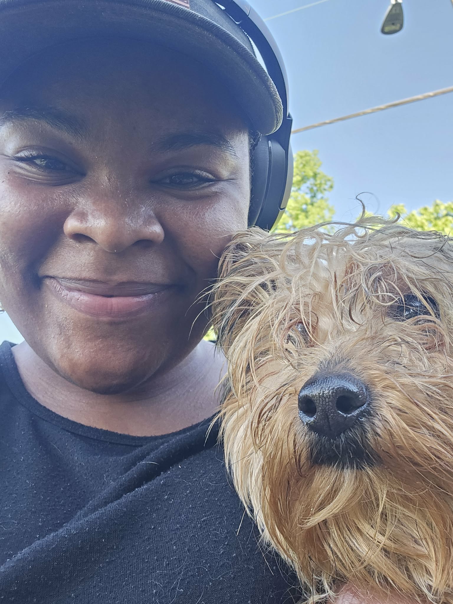A caregiver smiling beside a small brown dog outdoors, the moment trust begins