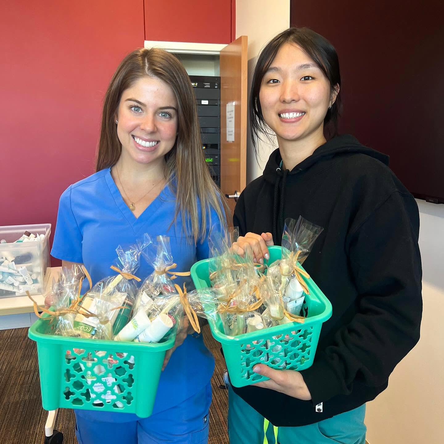 Two volunteers holding baskets filled with completed FACE bags