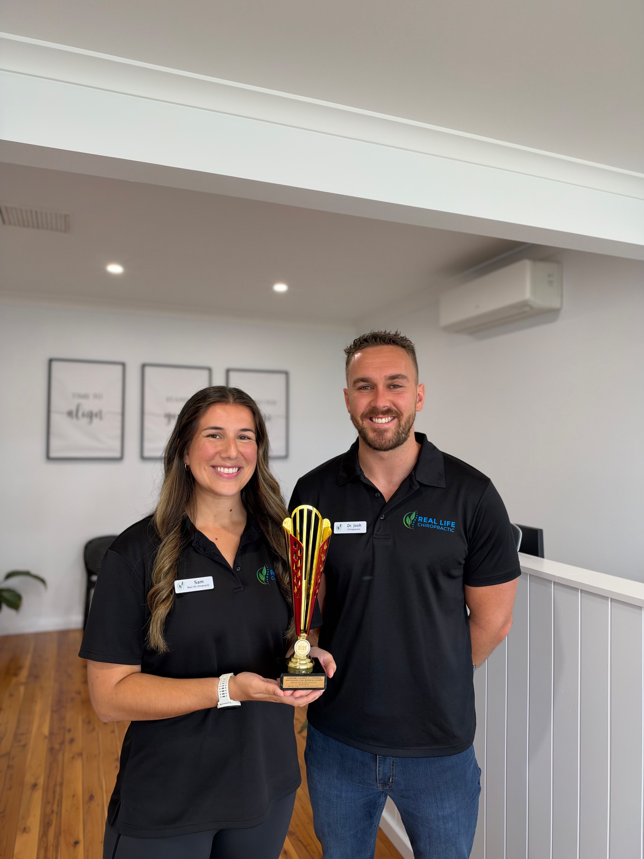 Real Life Chiropractic Narrabri team members Sam and Dr Josh holding the 2026 Best New Business trophy from the Narrabri Chamber of Commerce Whitehaven Coal Business Awards